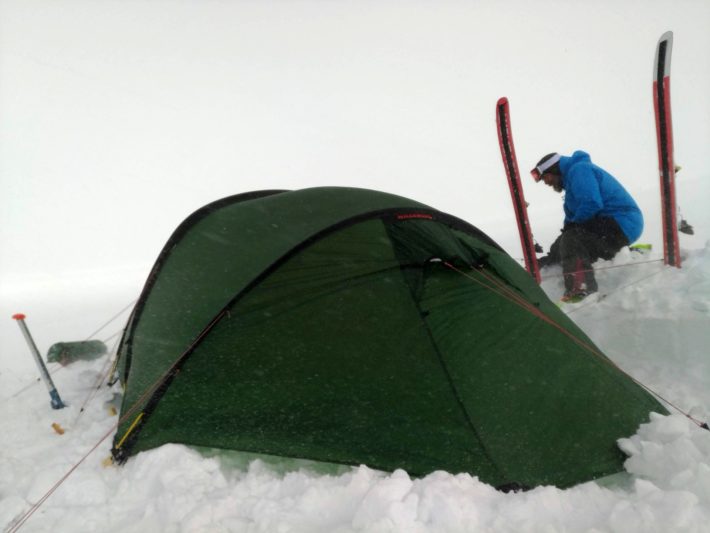 Martin säkrar tältet i snöyran.