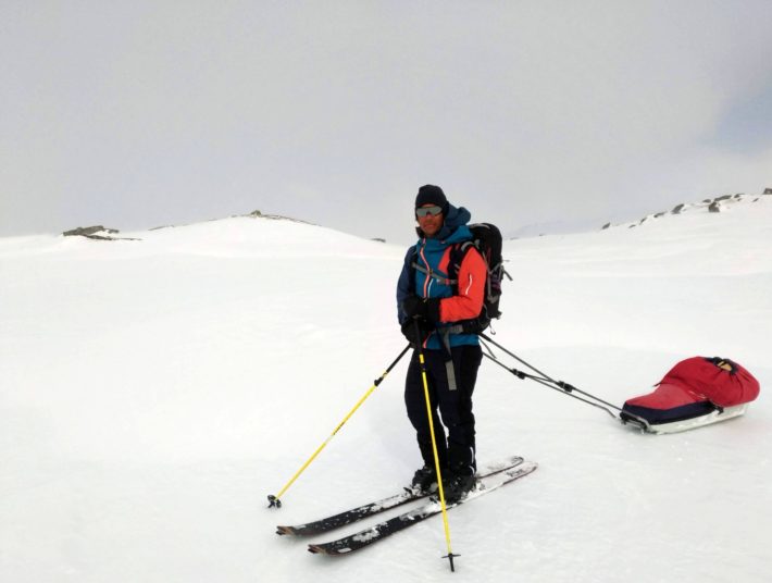 Jon Wagenius står på fjället med skidor och pulka.