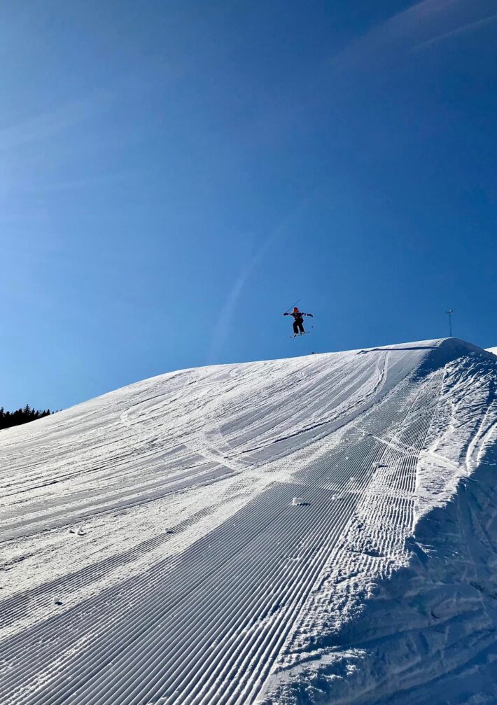 Skidåkare hoppar på stor hopp.