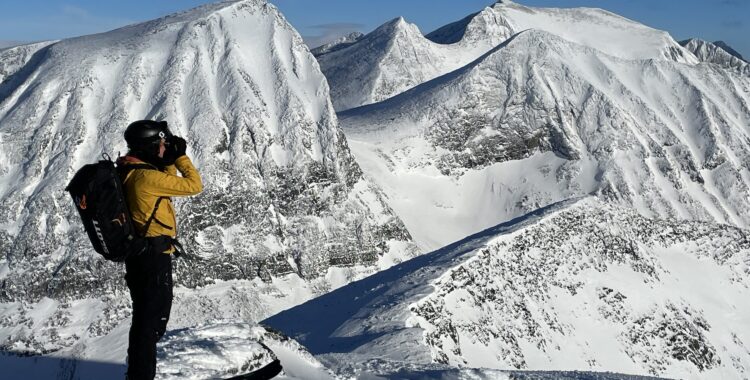 Jenny blickar ut över vindpinade fjäll.