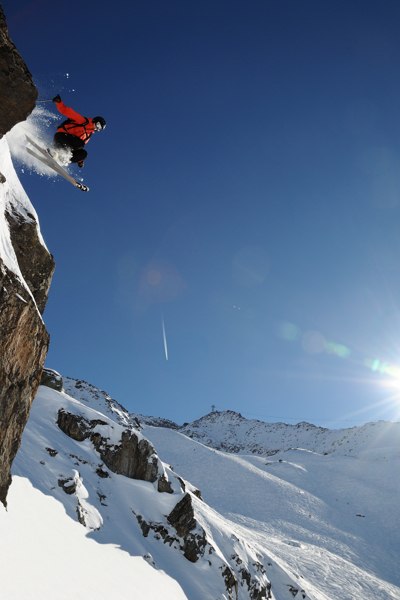 Christian droppar högt med sol, bergbana och pass. Foto: Erik Westberg. Åkare: Christian Oxling.