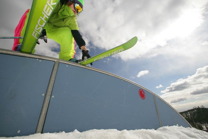 Regnbågsrail och gröna kläder samt skidor.

f. Foto: Kola produktions. Åkare: Julius Aspman.