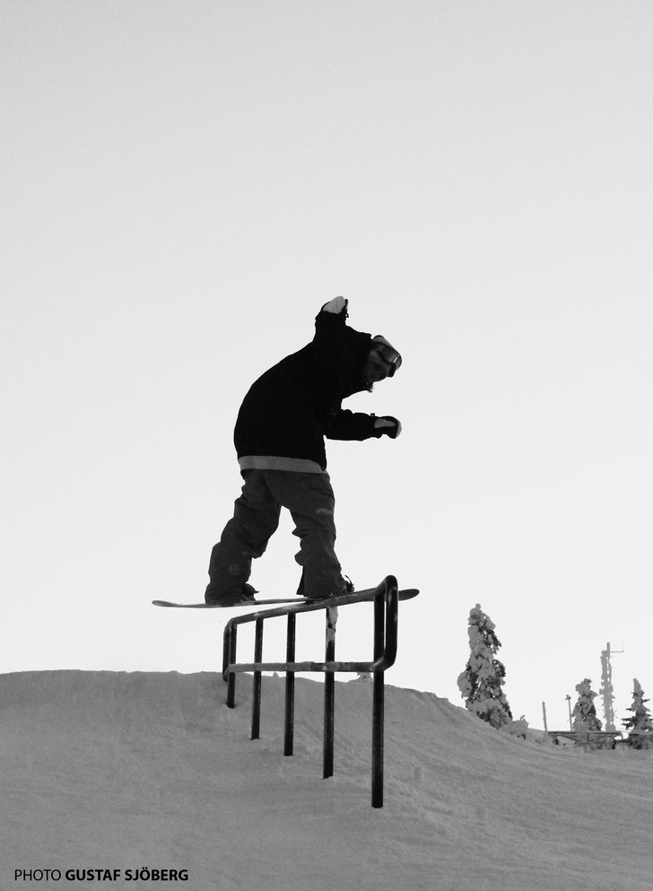 Jonas lägger en fs board på ett litet räcke i T. Foto: Gustaf Sjöberg. Åkare: Jonas Frid.