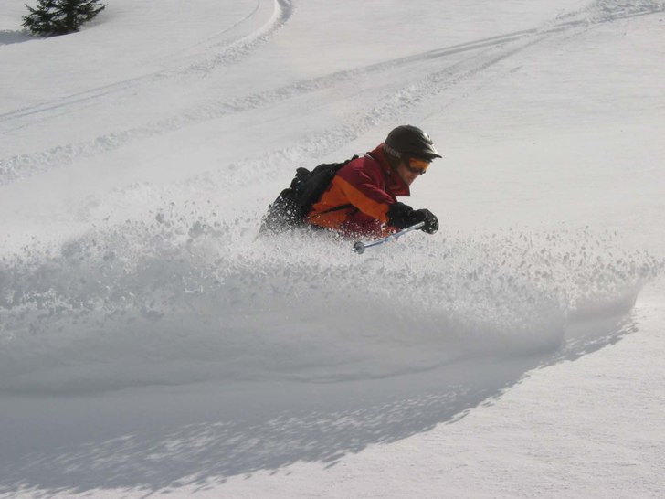 Foto: en mann med et kamera. Åkare: En mann med ski.