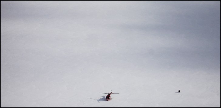 Helikoptern står och väntar nere på isen och so. Foto: Simon Pontér.