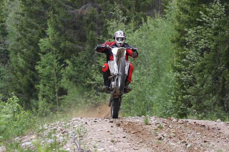 Fredrik tar upp en YZ450F på bakhjulet under en f. Foto: Jonas Emilsson. Åkare: Fredrik Thorén.