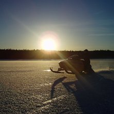 Testar ny skoter p&aring; isen utanf&ouml;r stugan, Solen i. Foto: Olov Nystr&ouml;m. &Aring;kare: Arvid Nystr&ouml;m.