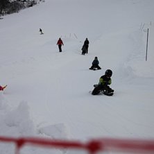 Egen l&oslash;ypa til kjelke, akebrett ved side av barne.