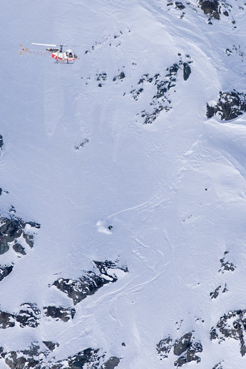 Loris Falquet på väg ner för berget i stora svängar, tätt följd av en helikopter.