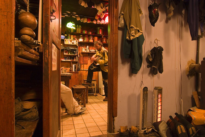 Carlos lirar lite gura efter maten i köket på Refugio Frey, medan vi tar det lugnt med ett glas rött.