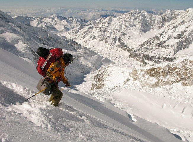 Fredrik åker i fin snö med Yalung glaciären I bakgrunden.