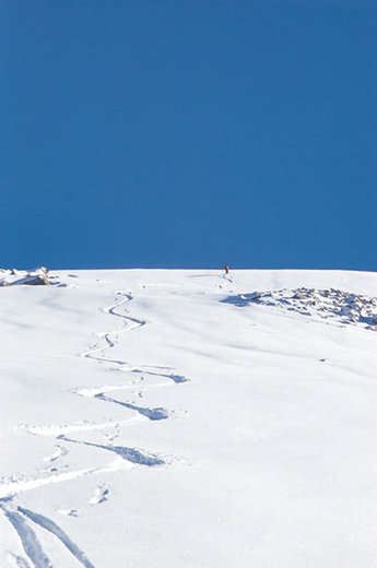 Marcus Sandersnäs åker ner mot Tinderskarsvattnet. Den blå färgen överst i bilden är Sätretindarnas skugga.