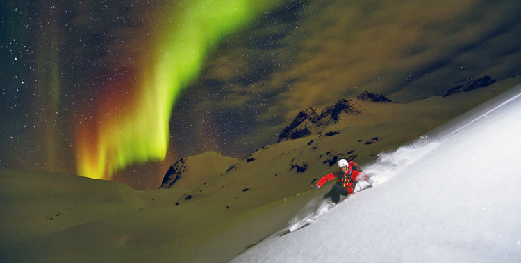 Och norrsken finns det på Senja. Oscar Hübinette njuter av skidåkning under den gröna himlen